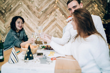 Cheerful friends clinking glasses with champagne