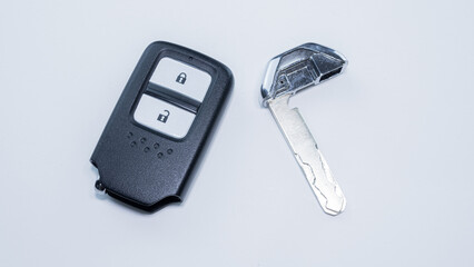 The car remote key has a black frame with 2 keys for Lock and Unlock placed on a white surface or background.