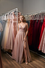 Young beautiful blonde girl wearing a full-length pale pink glitter chiffon draped prom ball gown....