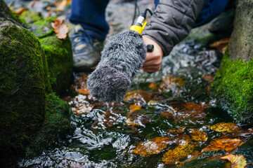 Hand holds a microphone gun to record sounds of nature. Sound technician records sounds of nature. Recording Ambient Sounds