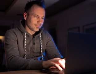 Man smiling and programing at night