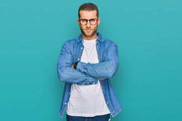 Young caucasian man wearing casual clothes skeptic and nervous, disapproving expression on face with crossed arms. negative person.