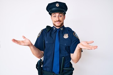 Young caucasian man wearing police uniform smiling showing both hands open palms, presenting and advertising comparison and balance