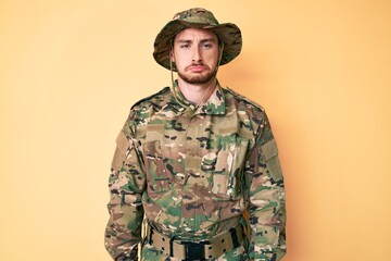 Young caucasian man wearing camouflage army uniform depressed and worry for distress, crying angry...