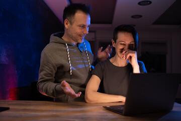 Man and woman having fun and surfing net at night