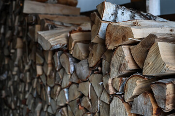 Close-up of birch firewood in wooden pile inside barn