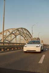 Modern electric car driving along city road