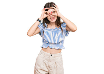 Young beautiful caucasian girl wearing casual clothes doing ok gesture like binoculars sticking tongue out, eyes looking through fingers. crazy expression.