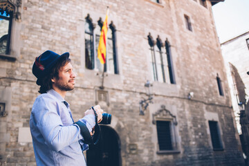 Fototapeta na wymiar Inspired man with camera strolling in old city