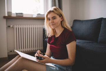 Smiling lady sitting with open marker for drawing on paper