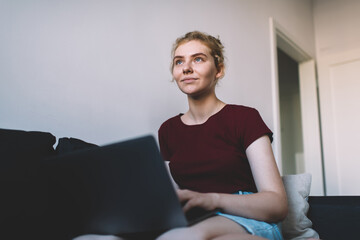 Positive woman browsing laptop at home