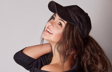 Very attractive young woman in a cap posing in studio