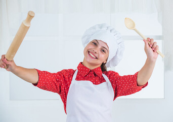 kid hold wooden spoon and rolling pin, cooking