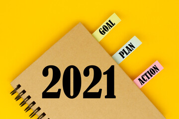 2021 New Year goal, plan, action text on notepad on yellow background. Business motivation, inspiration concepts
