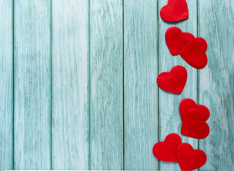 Line of red paper hearts on the blue-green backdrop with space for any text. Loving concept and card for Valentine's day.