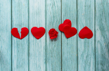 Heart in different shapes. Red paper hearts in raw on the wooden backdrop.  Broken heart and full shapes of the heart. Relationship and loving concept backdrop.
