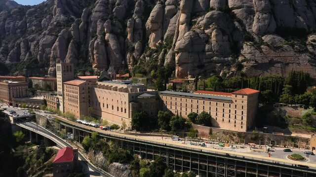 Montserrat monastery, Spain. Jun 2020. Beautiful view of landmark on a cliff. Striking built in the gorge as seen from top. High quality 4k footage