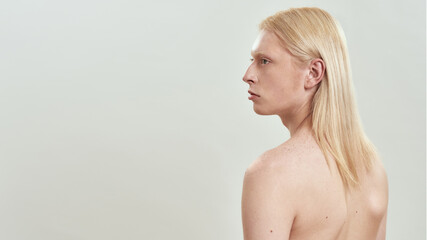 Young caucasian long haired blond shirtless man sideways