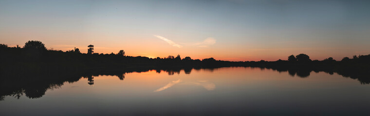 Obraz premium Sunset over a forest lake