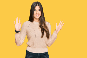 Young brunette woman wearing casual winter sweater showing and pointing up with fingers number nine...