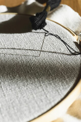 Closeup of threaded needle embroidering on embroidery hoop 
