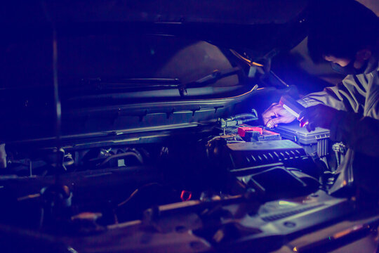 Selec tive focus to the mechanic's hand is unscrewing a nut to replace the car battery. Delivery car maintenance on road or home. The concepts of car maintenance services in every location.