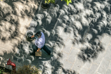 Real people oblivious to what is happening around them: minicelipses in the projection view of the shadows of leafs and trees branches in the streets during the Partial Solar Eclipse in Santiago city