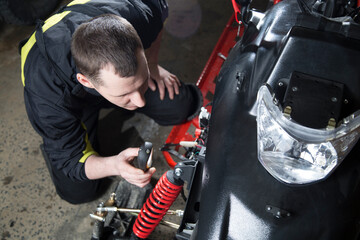 Fototapeta na wymiar Repair and maintenance of snowmobiles. Maintenance of motor vehicles.