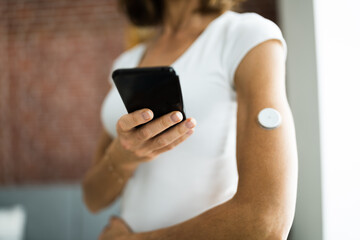 Woman Testing Glucose Level With Continuous Glucose Monitor