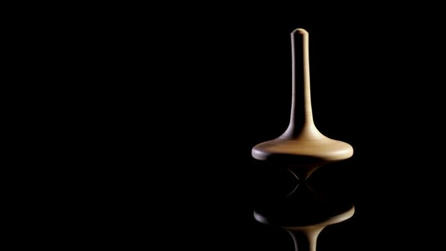 Close up shot of a wooden spinning top moving.