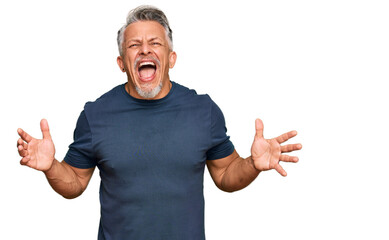 Middle age grey-haired man wearing casual clothes crazy and mad shouting and yelling with...