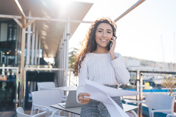 Half length portrait of successful female manager of street cafeteria holding delivery contract in...