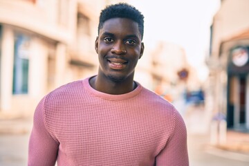 Young african american man smiling happy standing at the city.