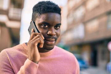 Young african american man smiling happy talking on the smartphone at the city.