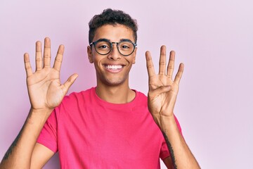 Young handsome african american man wearing glasses over pink background showing and pointing up...