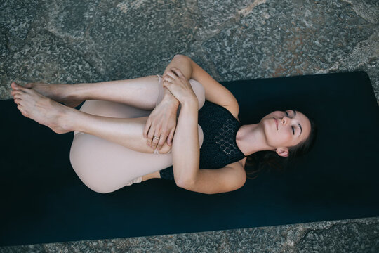 Relaxed woman doing Wind Removing yoga asana