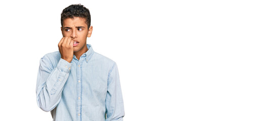 Young handsome african american man wearing casual clothes looking stressed and nervous with hands on mouth biting nails. anxiety problem.