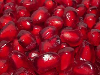 Pomegranate, juicy red grains, close-up, macro photo. Healthy food, berries full of vitamins, natural nutrition.