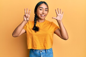 Young latin woman wearing casual clothes showing and pointing up with fingers number eight while smiling confident and happy.