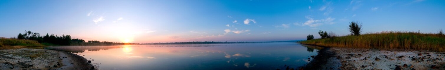 Panoramic view of a calm lake on a sunny summer day