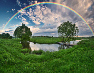 Fototapeta na wymiar Landscape with a Rainbow on the River in Spring. colorful morning