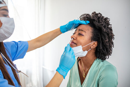 Doctor In A Protective Suit Taking A Throat And Nasal Swab From A Patient To Test For Possible Coronavirus Infection. Nasal Mucus Testing For Viral Infections. COVID-19 Testing Health Care Concept.