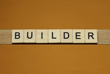 gray word builder made of wooden square letters on brown background