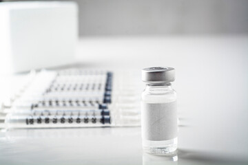 vaccine and ampoule on table with blurred background