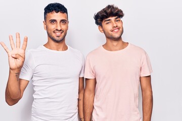 Young gay couple wearing casual clothes showing and pointing up with fingers number four while smiling confident and happy.