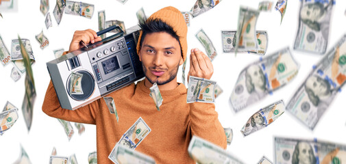 Handsome latin american young man holding boombox, listening to music doing italian gesture with...