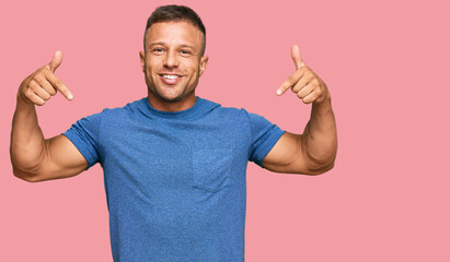 Handsome muscle man wearing casual clothes looking confident with smile on face, pointing oneself...