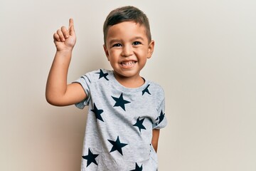 Adorable latin toddler wearing casual clothes smiling with an idea or question pointing finger up with happy face, number one