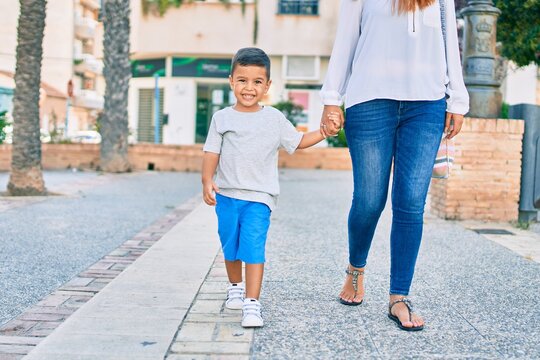 Adorable latin mother and son walking at the city.