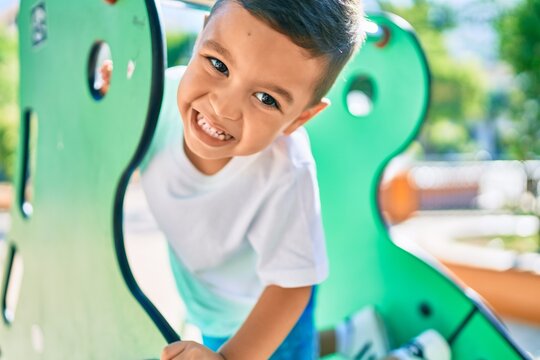 Adorable hispanic boy smiling happy playing at the park.